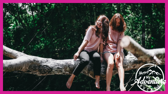 
Two-girls-sitting-on-a-log-how-to-overcome-travel-anxiety